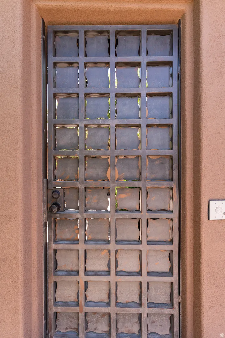 Wrought iron entry gate with a grid pattern and decorative square inserts