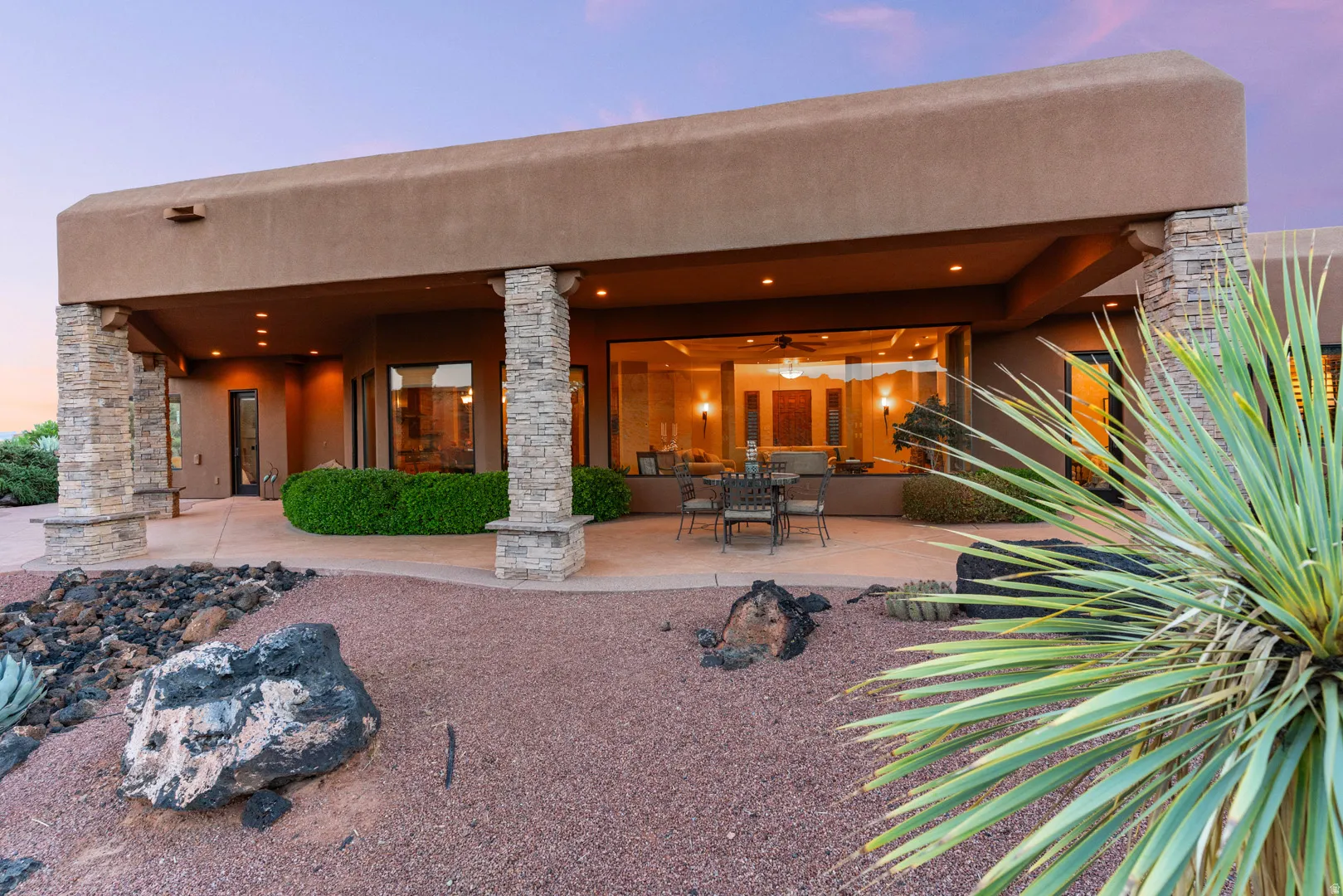 Expansive covered patio featuring stacked stone columns and recessed lighting