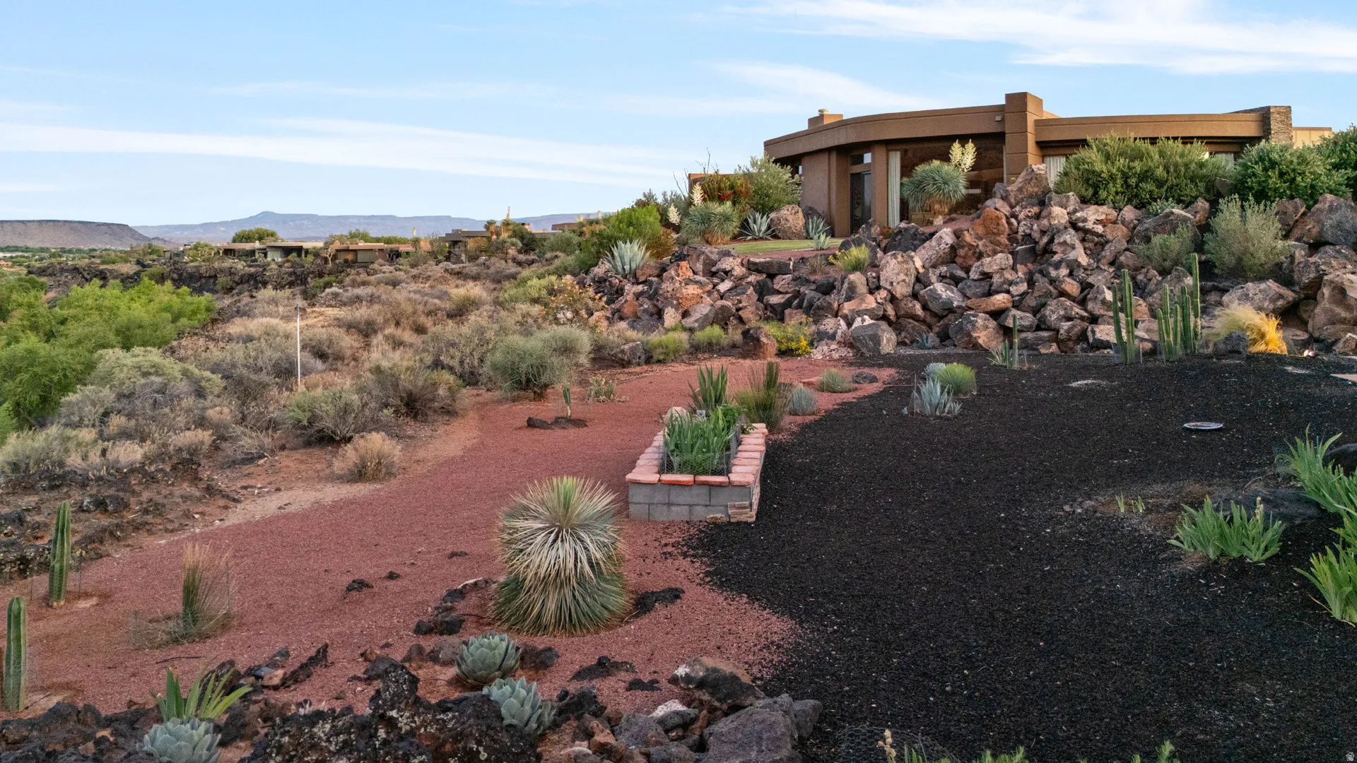 Desert landscape featuring xeriscaping, natural rock formations, and varied cacti