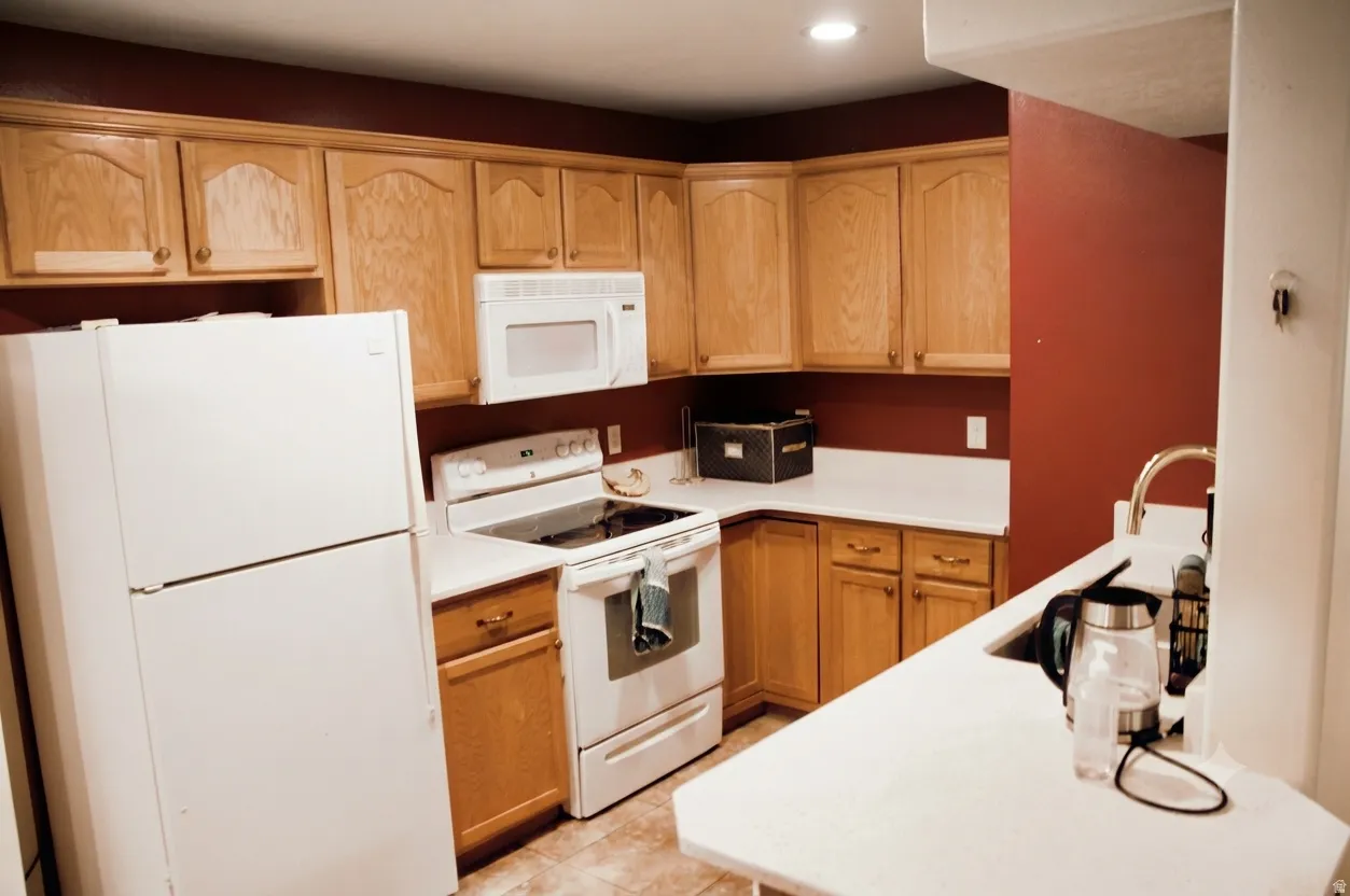 Kitchen featuring light wood cabinetry, white countertops, built-in microwave, and recessed lighting