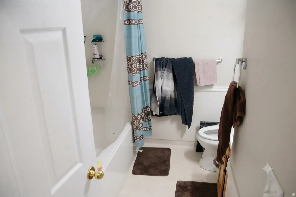 White tub and shower combination with a standard toilet