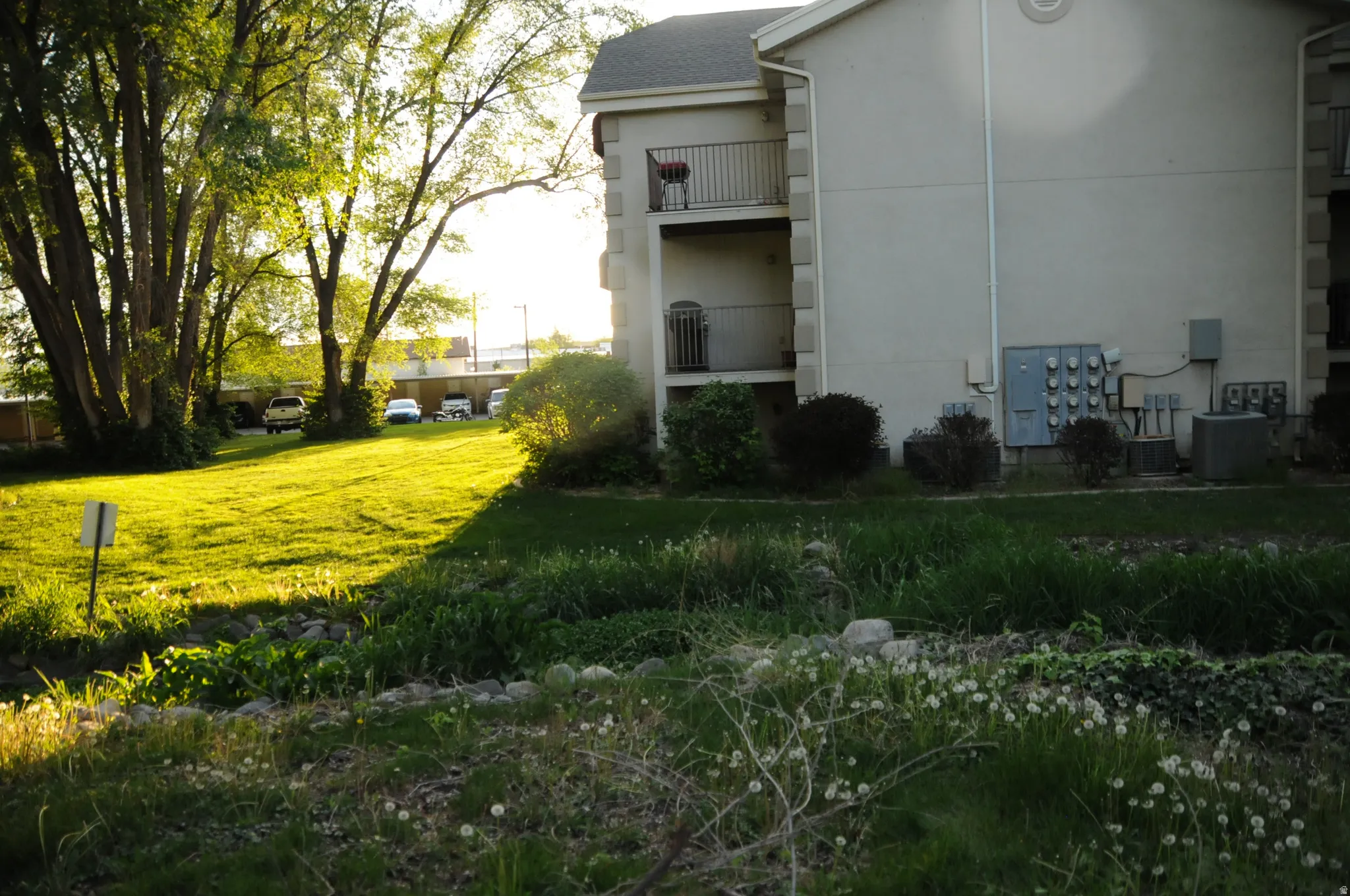 View of grassy yard featuring a balcony