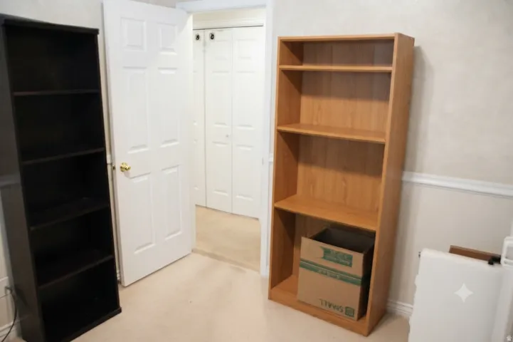 Neutral-toned carpeting paired with white baseboards and chair rail molding