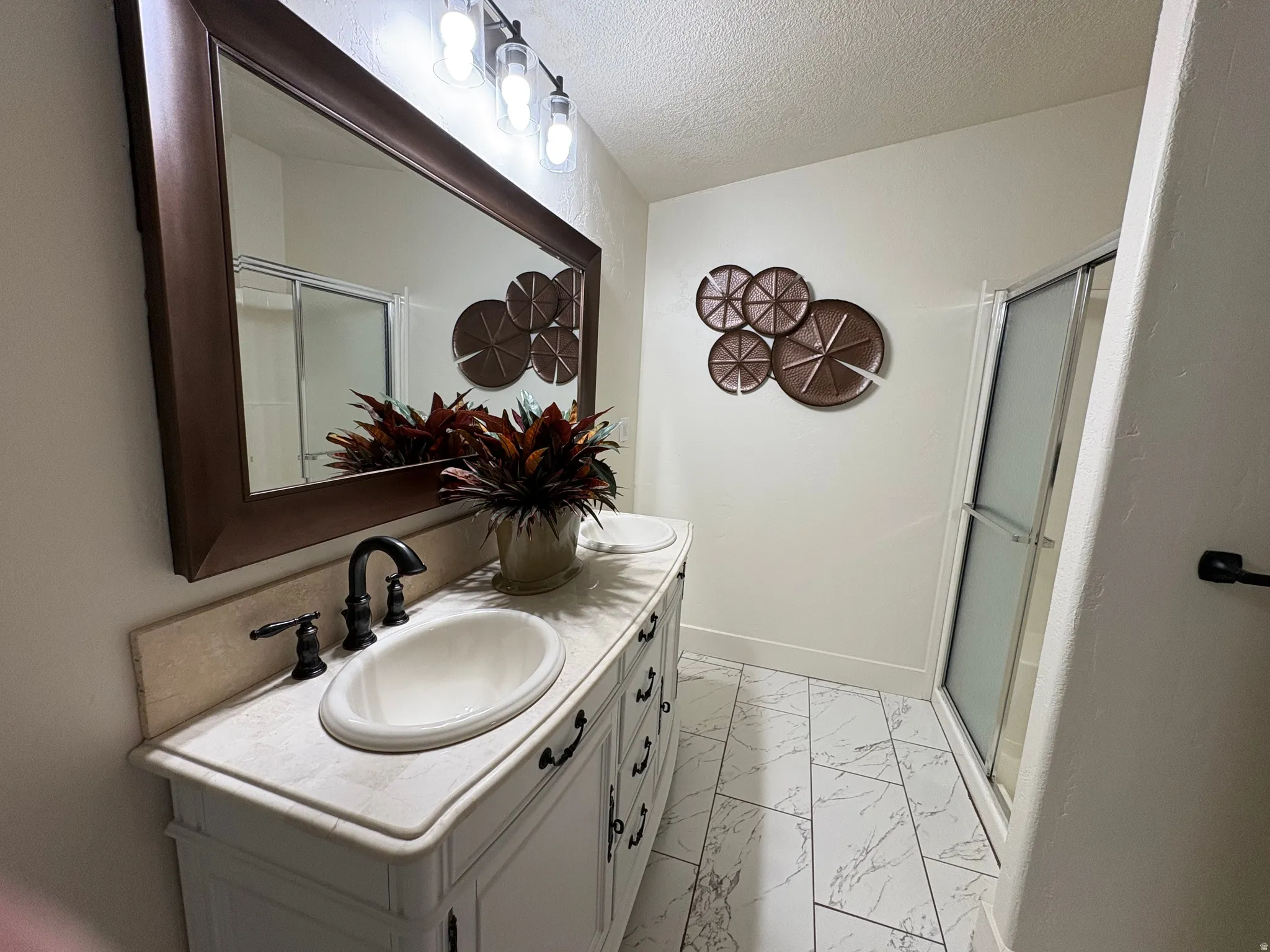 Double vanity with an integrated countertop and undermount sinks, featuring dark bronze faucets and hardware
