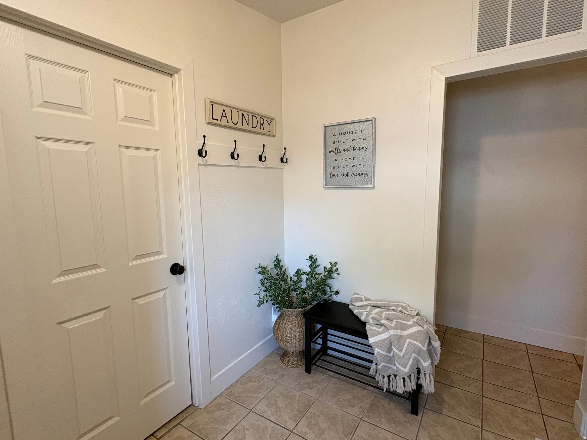 Tiled flooring extends through this area, complemented by a white paneled door with a black knob