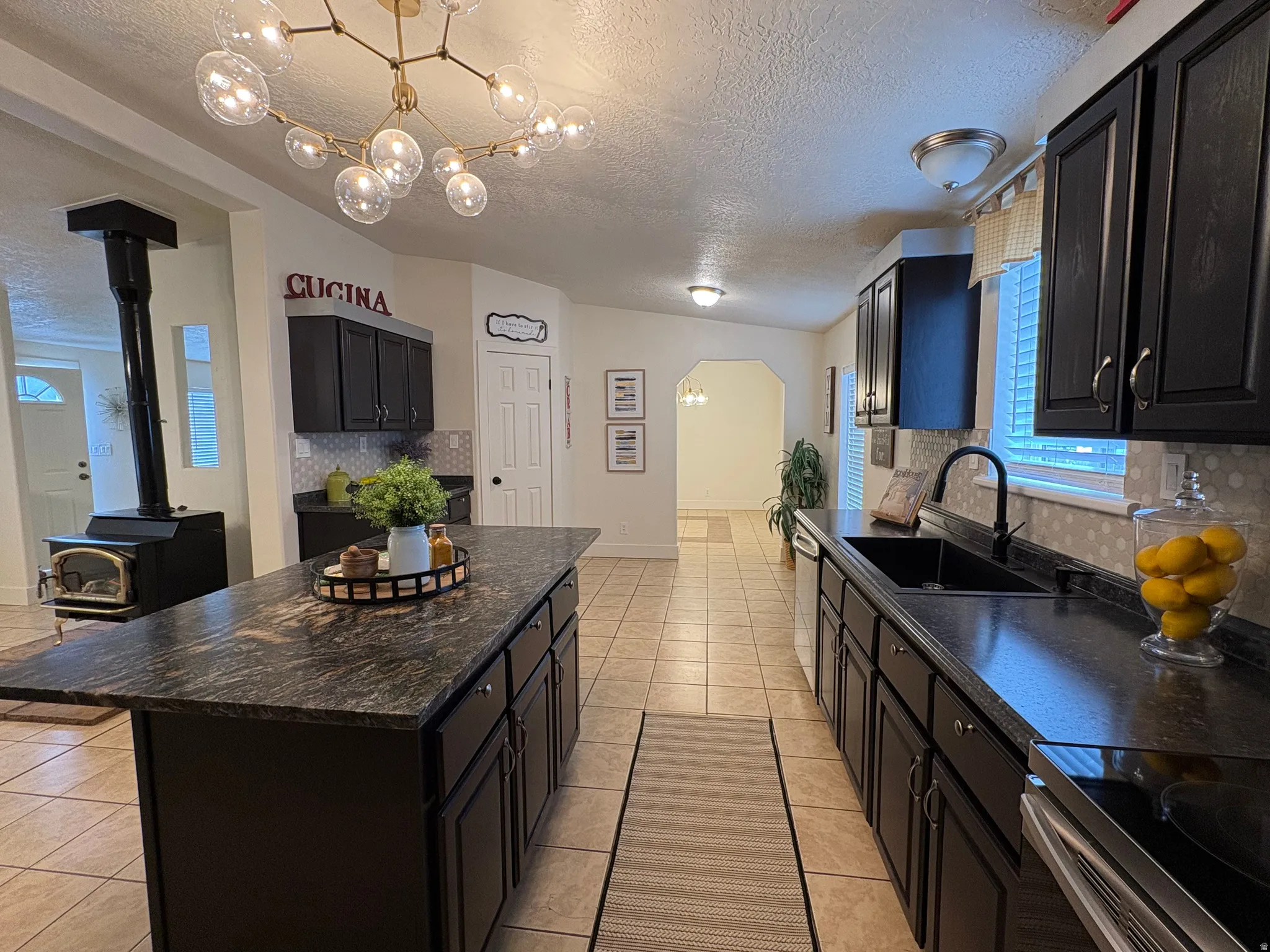 Kitchen featuring dark cabinetry, speckled countertops, and tile flooring