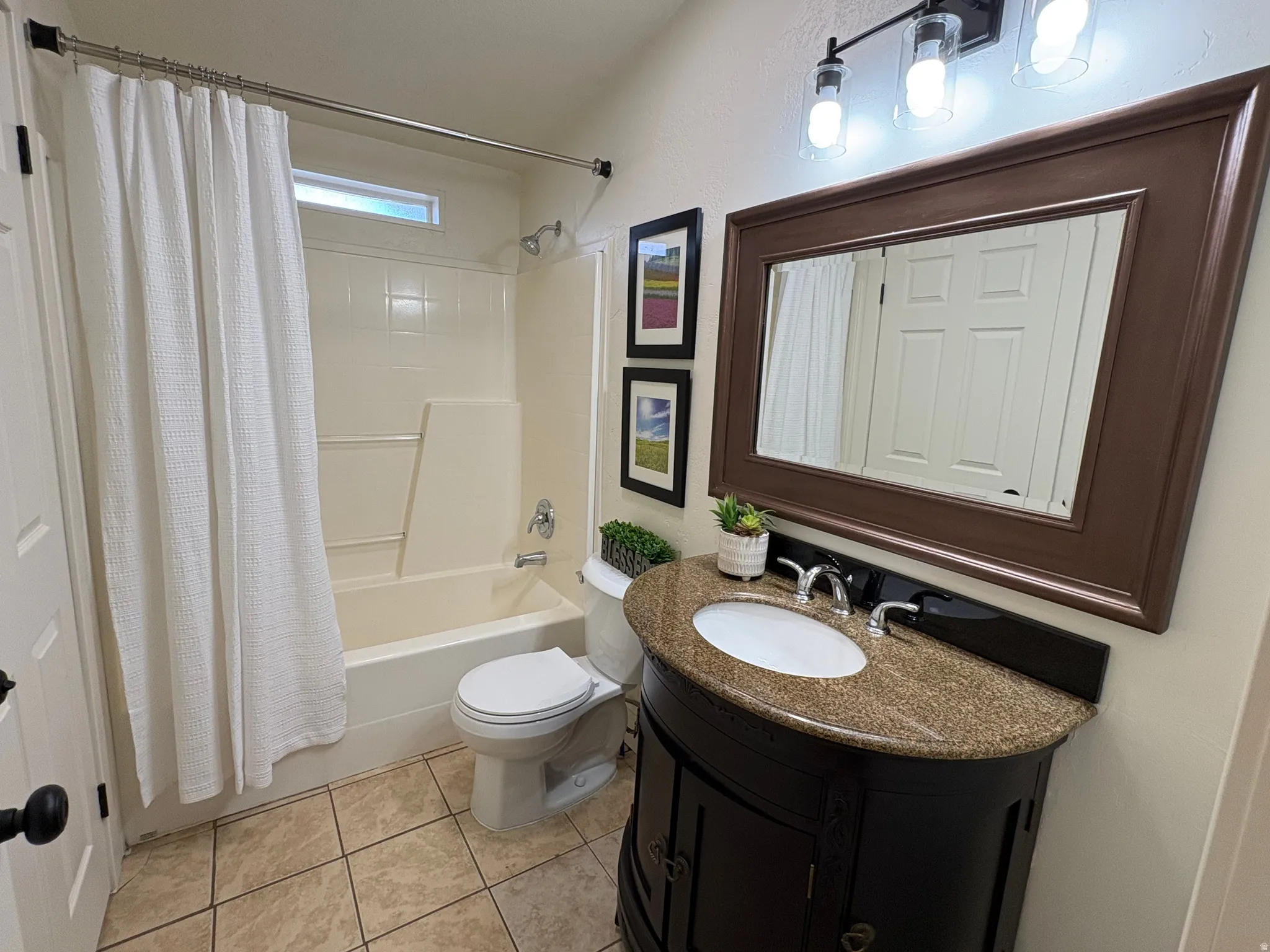 Bathroom featuring a dark wood vanity with a granite countertop, undermount sink, and polished chrome faucet