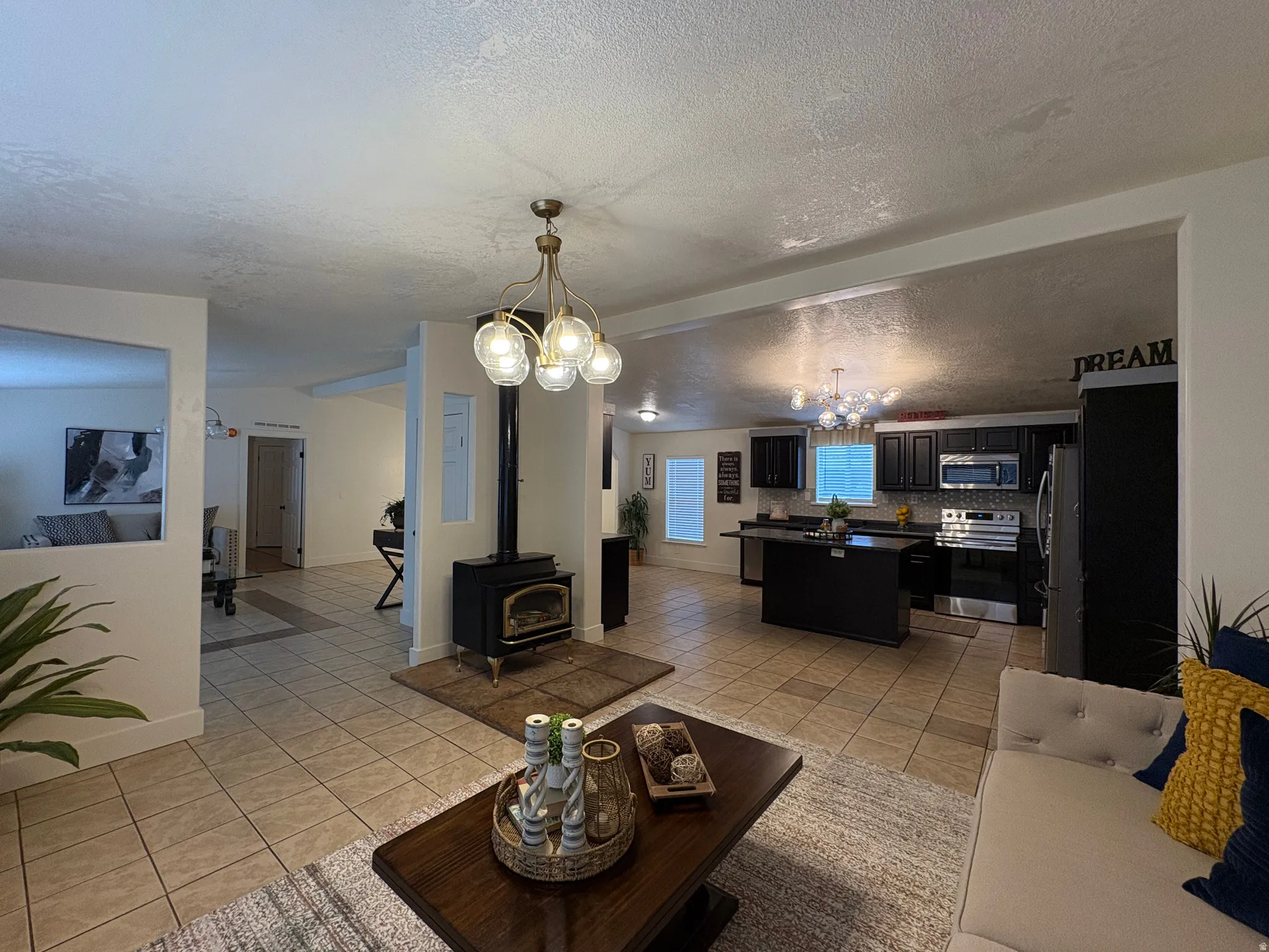 Open-concept living area with tile flooring and a central wood-burning stove