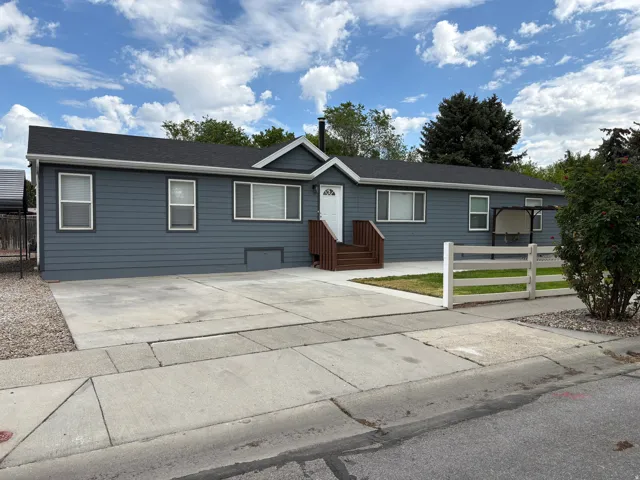 Exterior featuring dark blue siding, white trim, and a dark shingle roof
