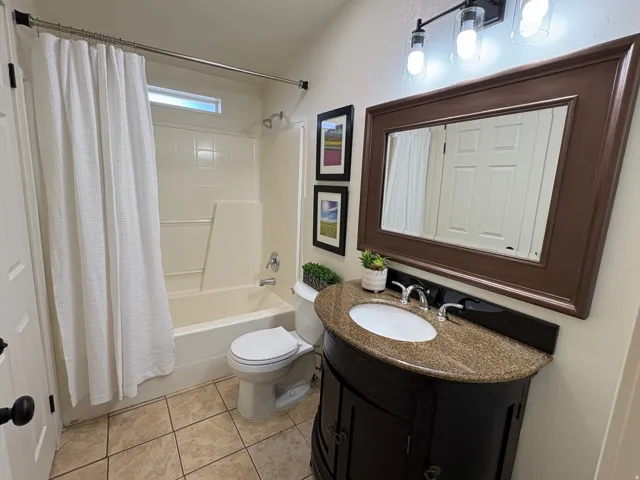 Bathroom featuring a dark wood vanity with a granite countertop, undermount sink, and polished chrome faucet