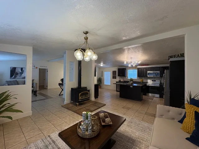 Open-concept living area with tile flooring and a central wood-burning stove