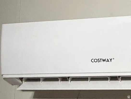 Wall-mounted white air conditioning unit with a digital display and remote control