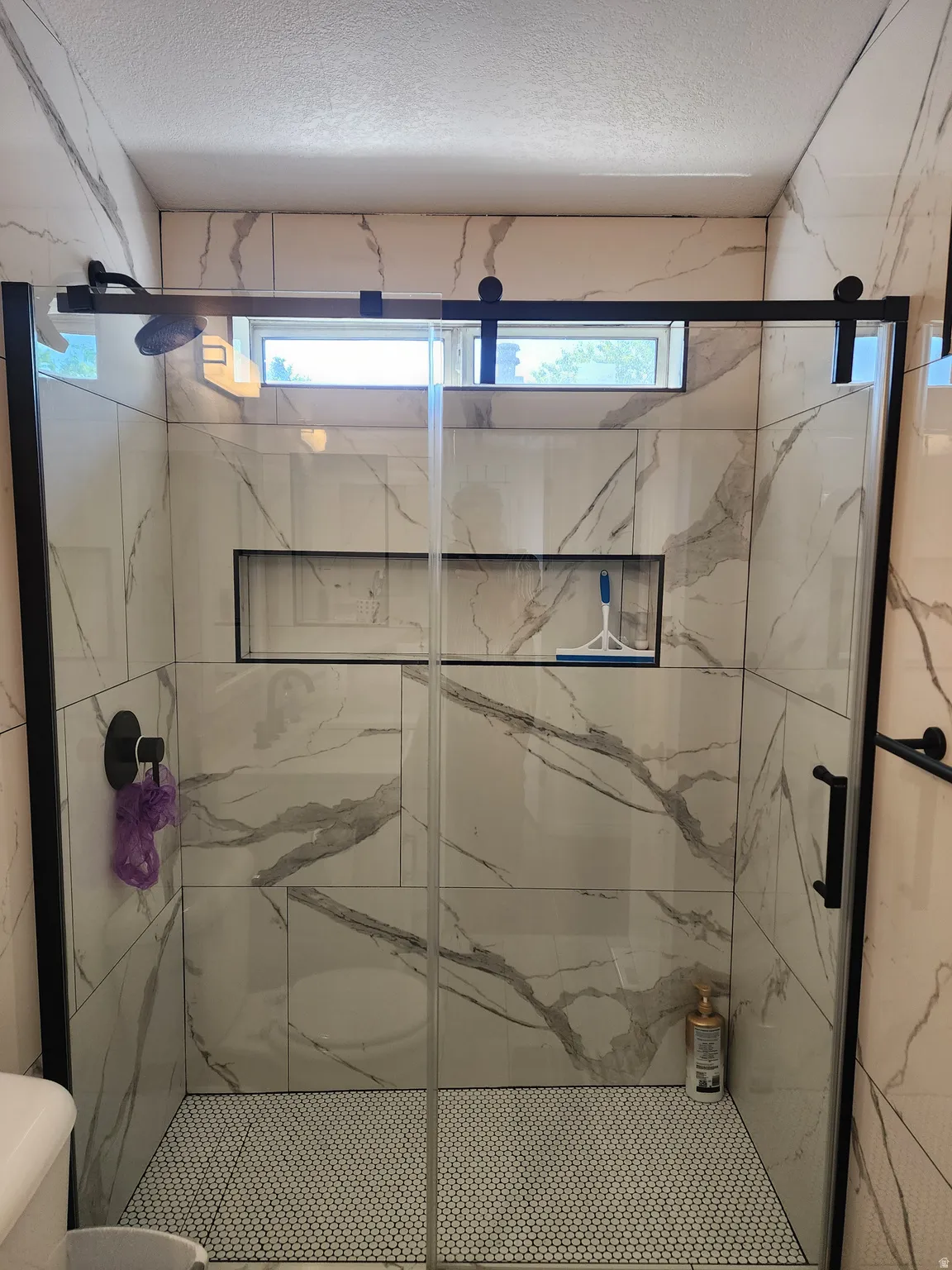 Shower enclosure featuring clear glass panels with matte black hardware