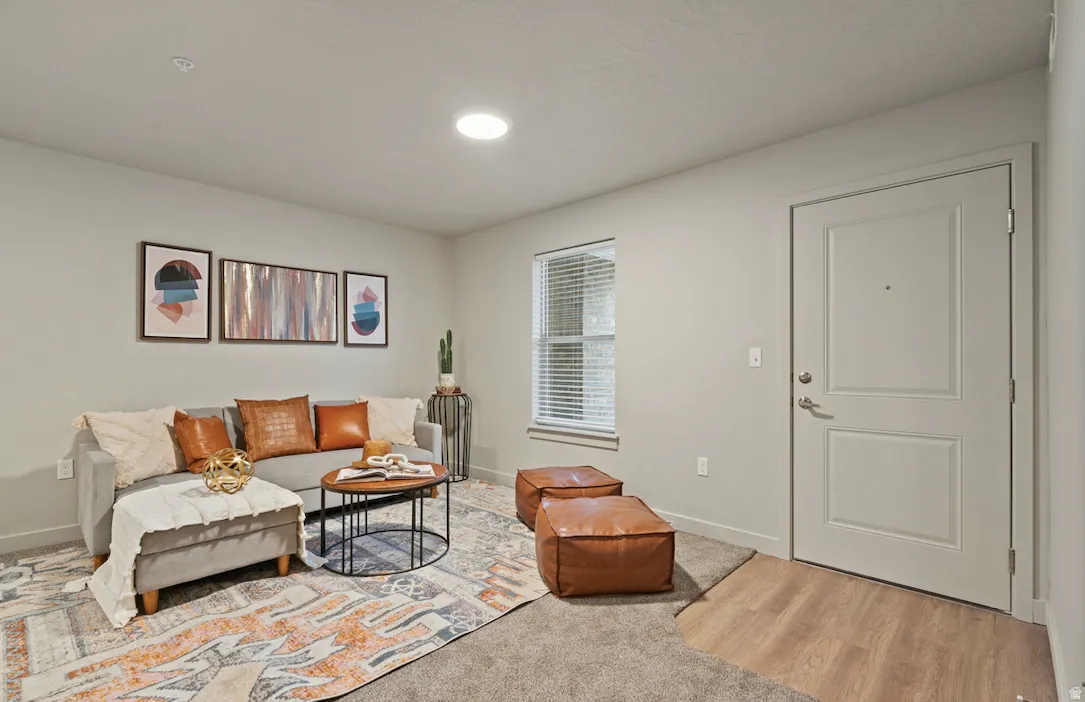 Living space featuring a light gray interior door with paneling, recessed lighting, and wood-finish flooring at the entry