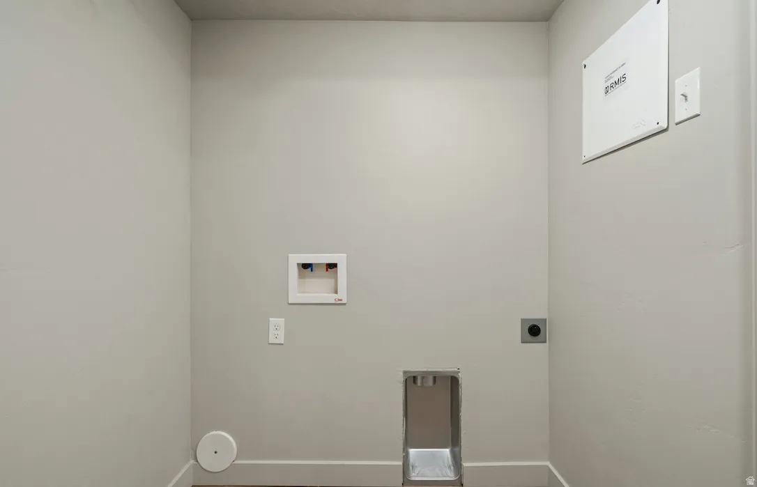 Dedicated laundry area featuring a washer hookup, dryer vent, electrical outlets, and a utility access panel