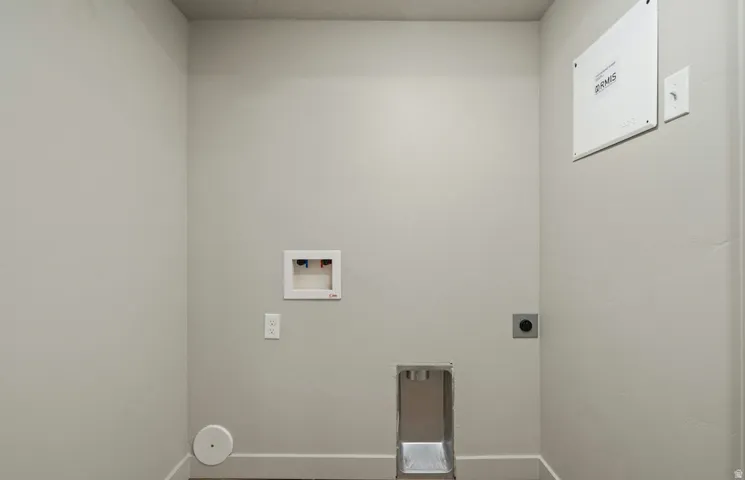 Dedicated laundry area featuring a washer hookup, dryer vent, electrical outlets, and a utility access panel