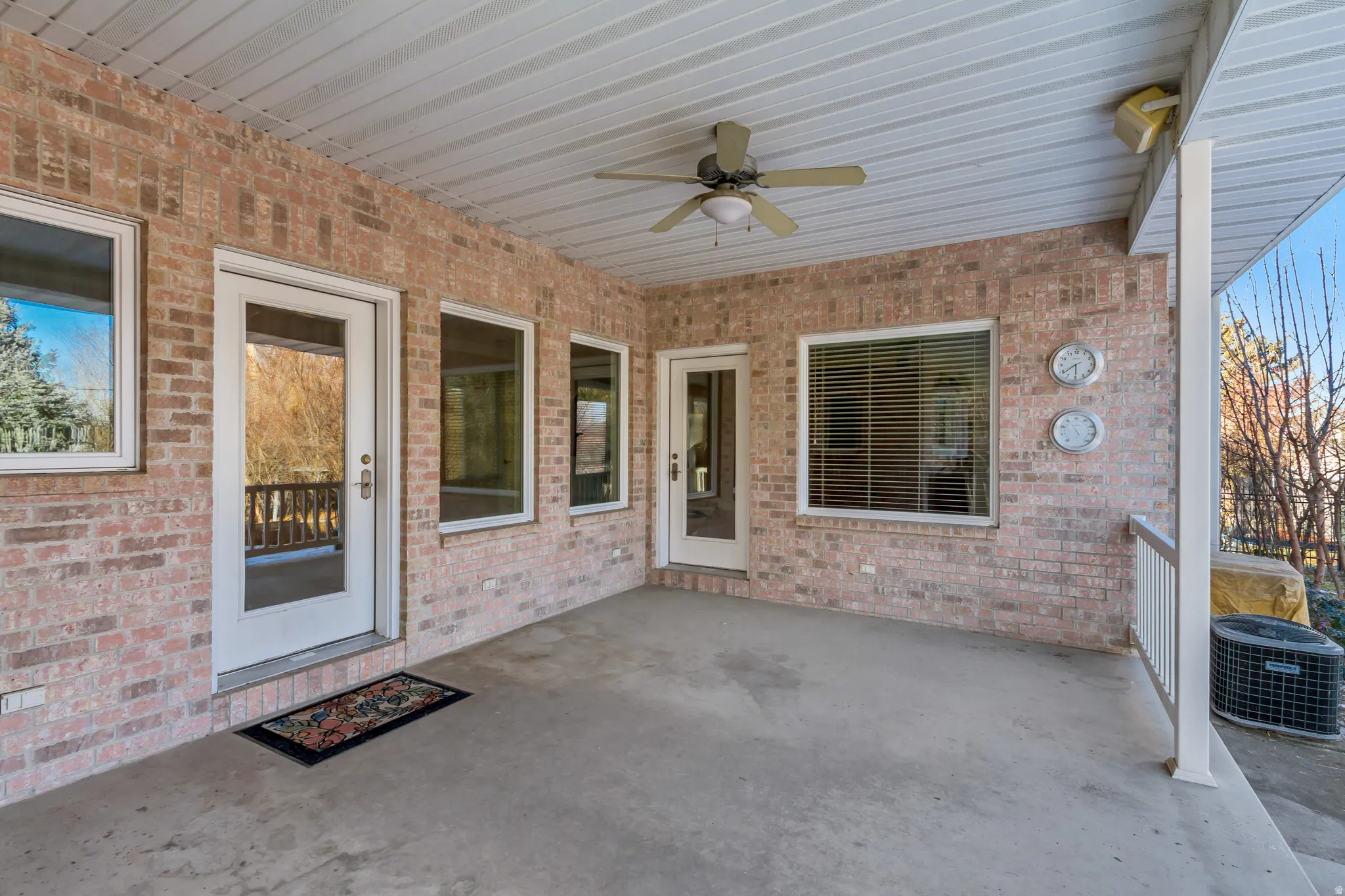 Covered concrete patio featuring a brick exterior and a white vinyl ceiling