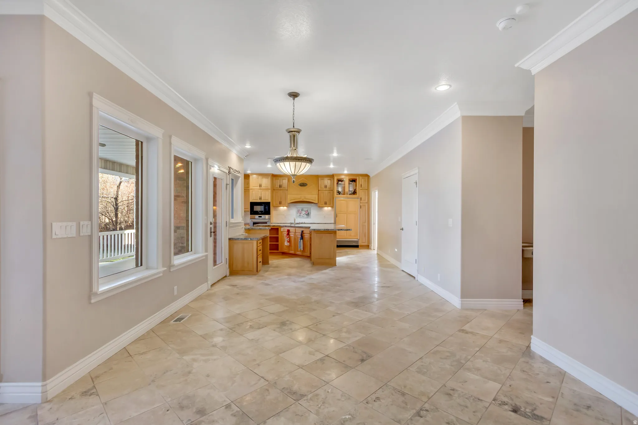 Spacious room featuring large format tile flooring, crown molding, and recessed lighting