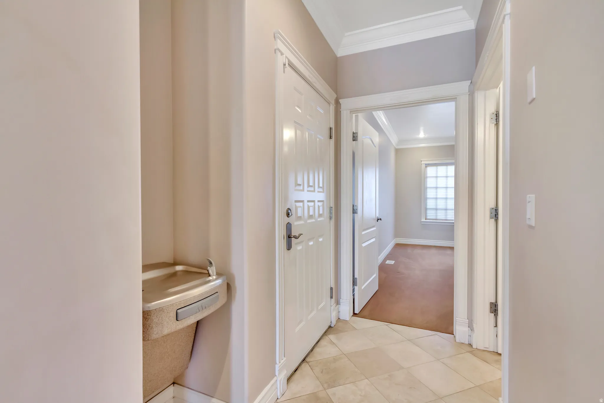 Entryway featuring square tile flooring, a built-in water fountain, and multiple paneled doors