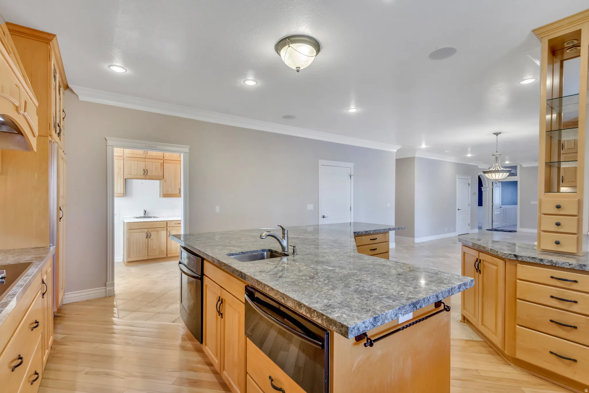 Kitchen featuring light wood cabinetry, stone-finish countertops, stainless steel appliances, and wood-finish flooring