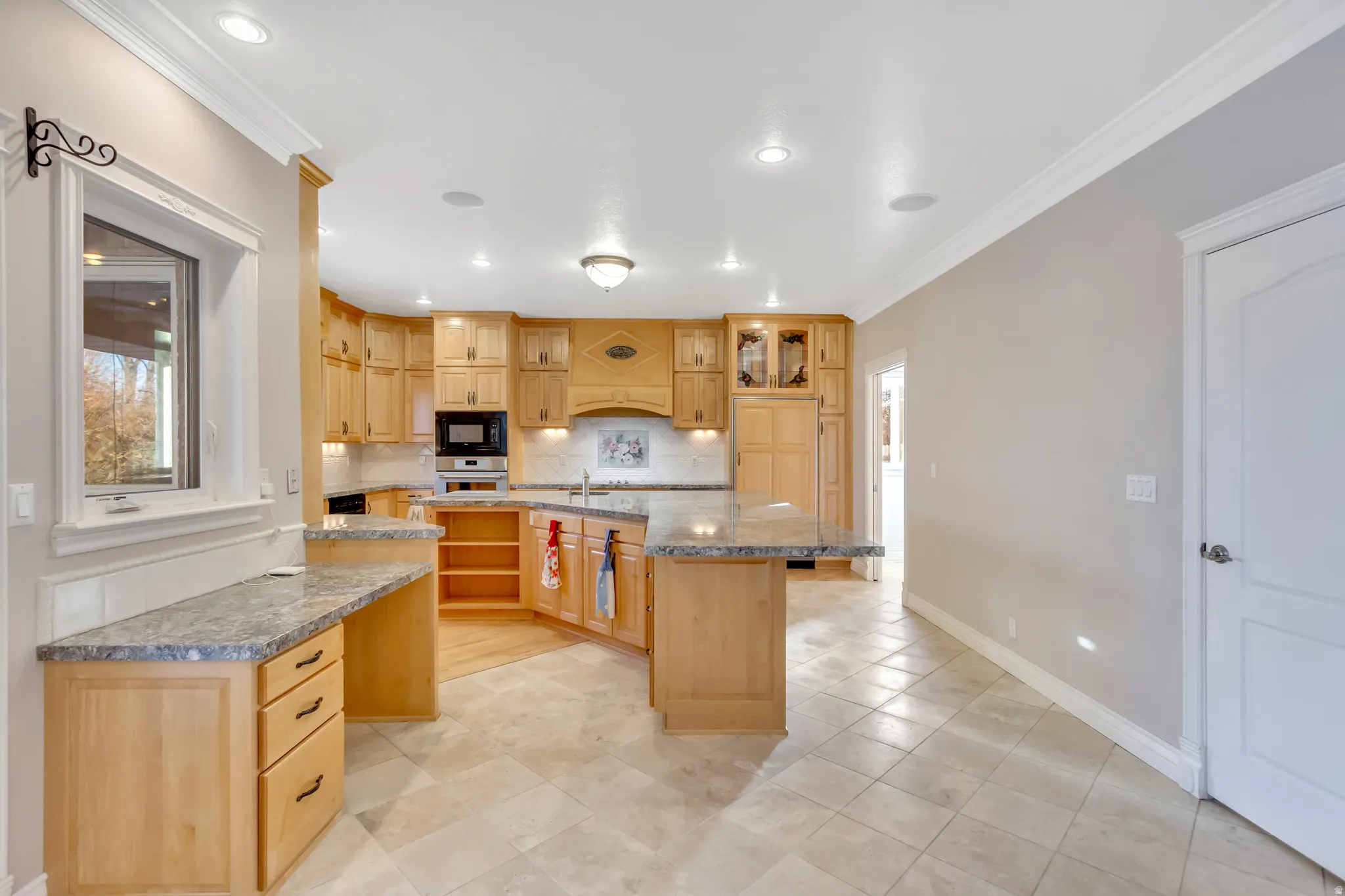 Kitchen featuring light wood cabinetry, stone countertops, and recessed lighting