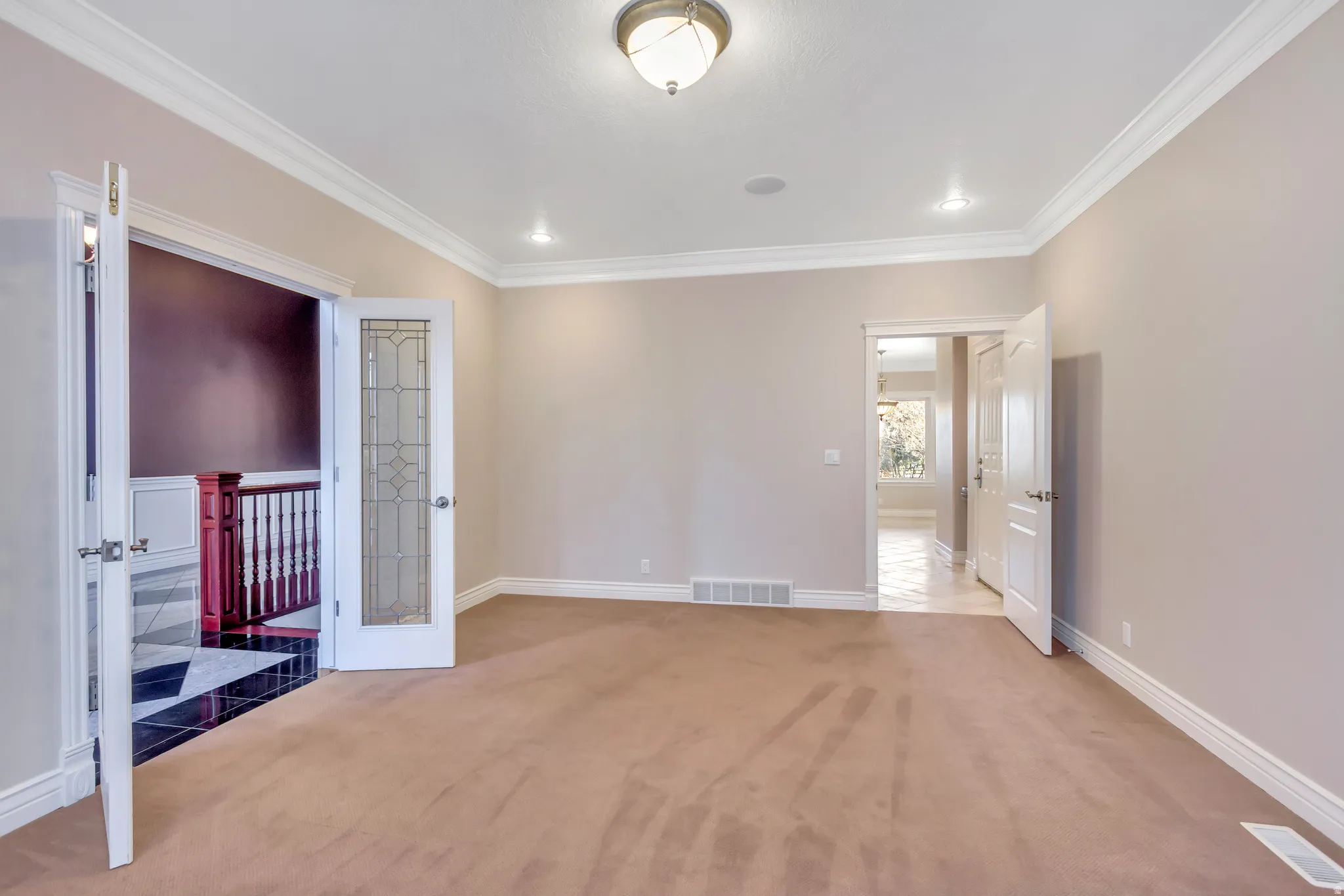 Spacious room featuring neutral wall paint and plush carpeting
