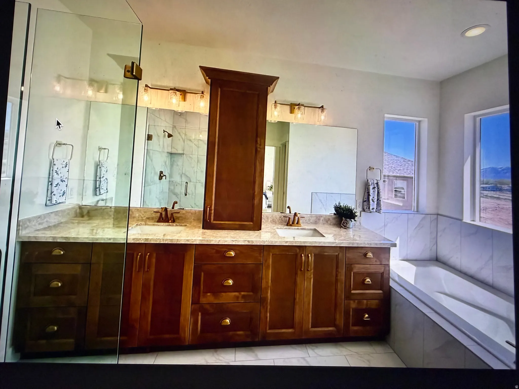 Spacious bathroom featuring a dual vanity with wood cabinetry, light-toned countertops, and dual mirrors