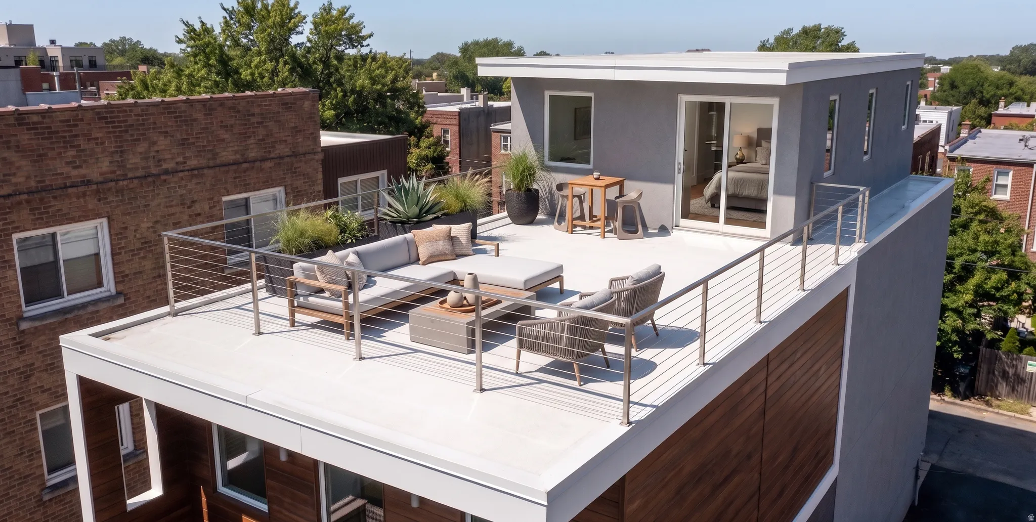 Rooftop terrace featuring a modern cable railing system and direct access to an upper-level room through a glass sliding door