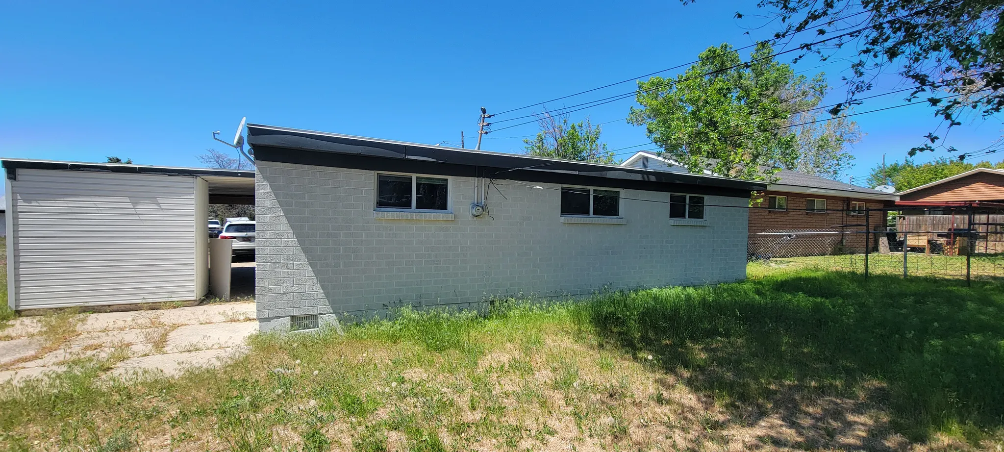 Exterior structure featuring light-colored brick siding, a flat roofline with dark trim, and multiple rectangular windows