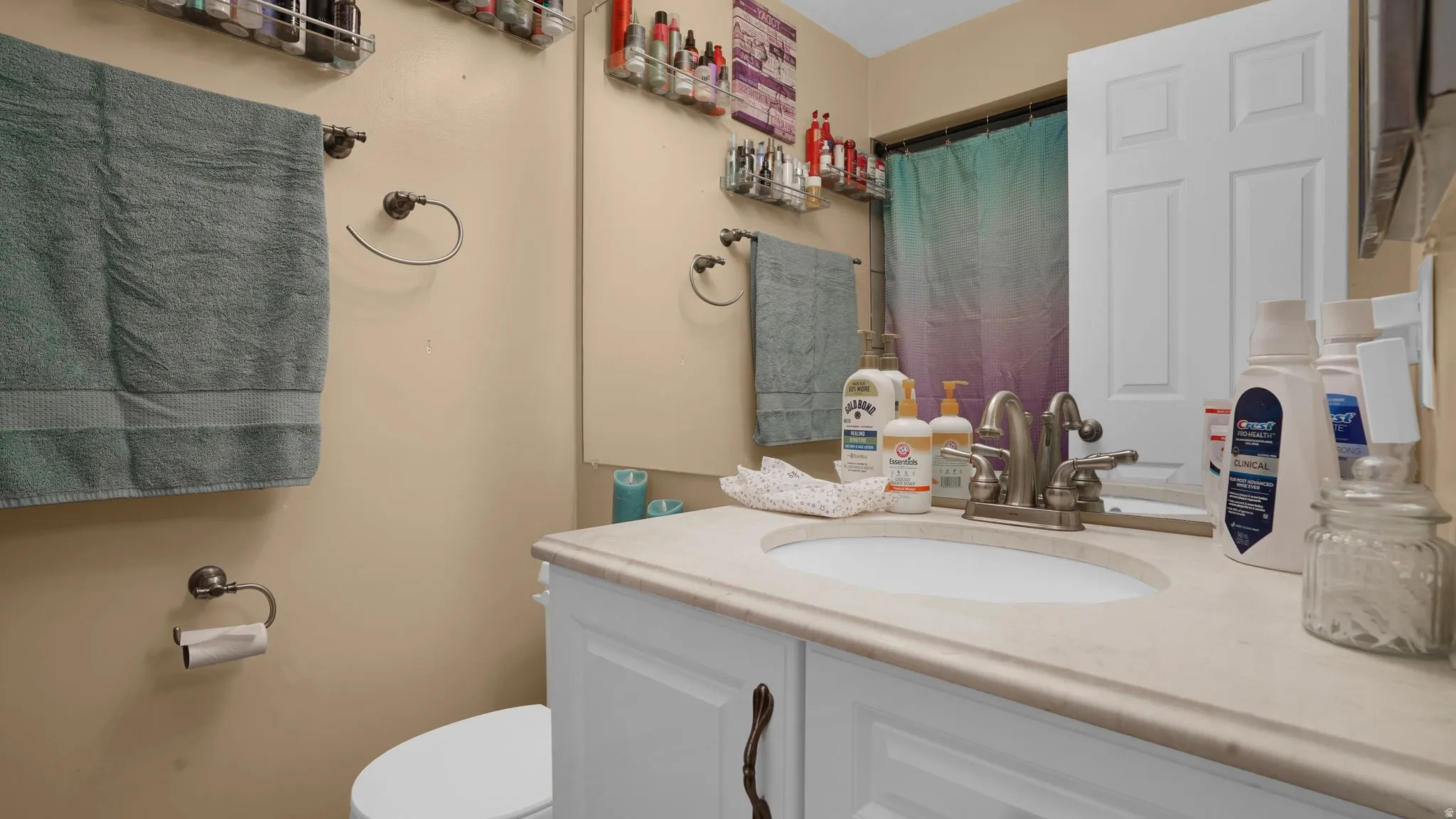 Bathroom featuring a white vanity with panel detailing, stone-finish countertop, undermount sink, and a brushed nickel faucet