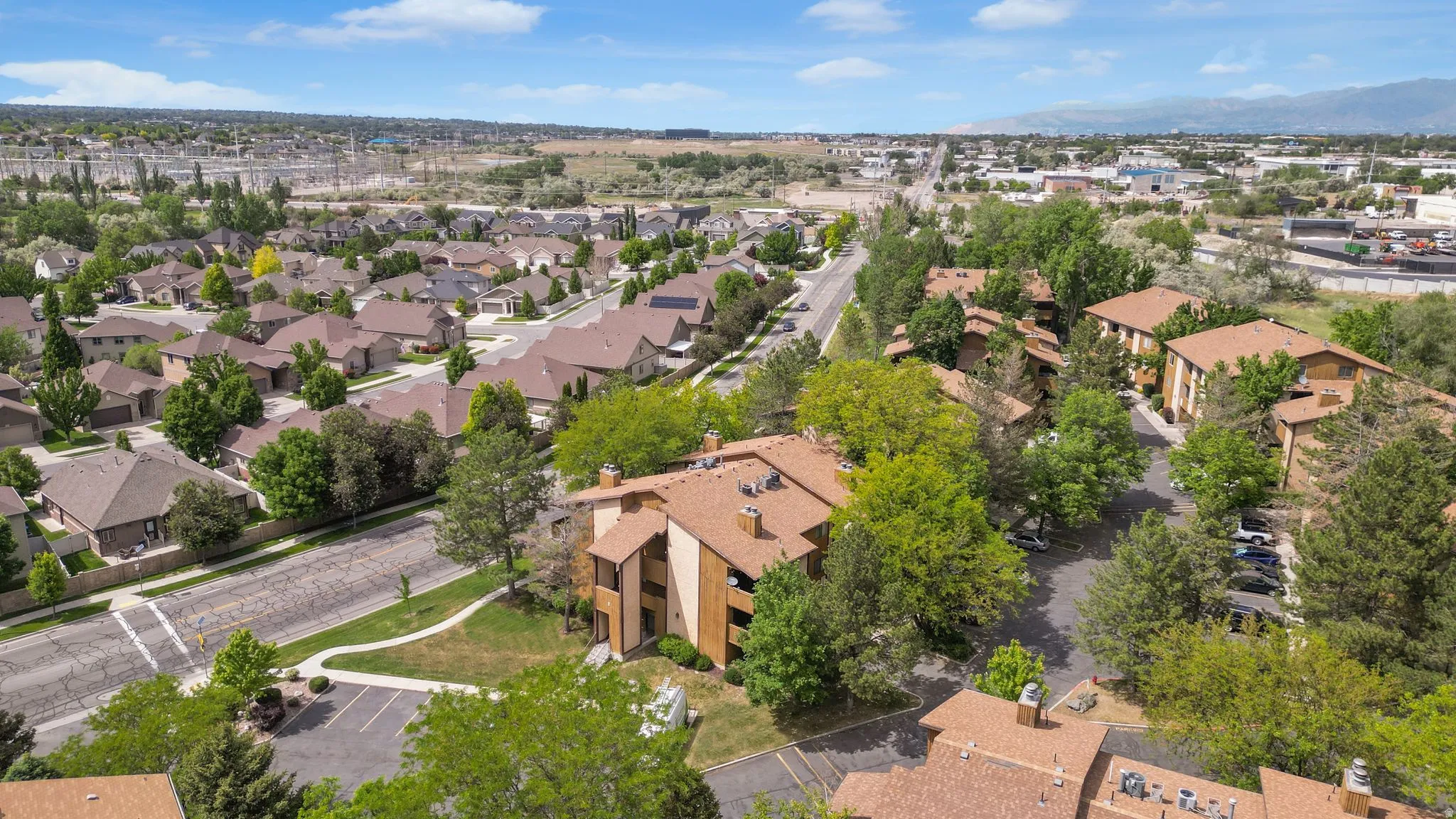 Aerial perspective showcasing a residential community with abundant mature trees and varied rooflines