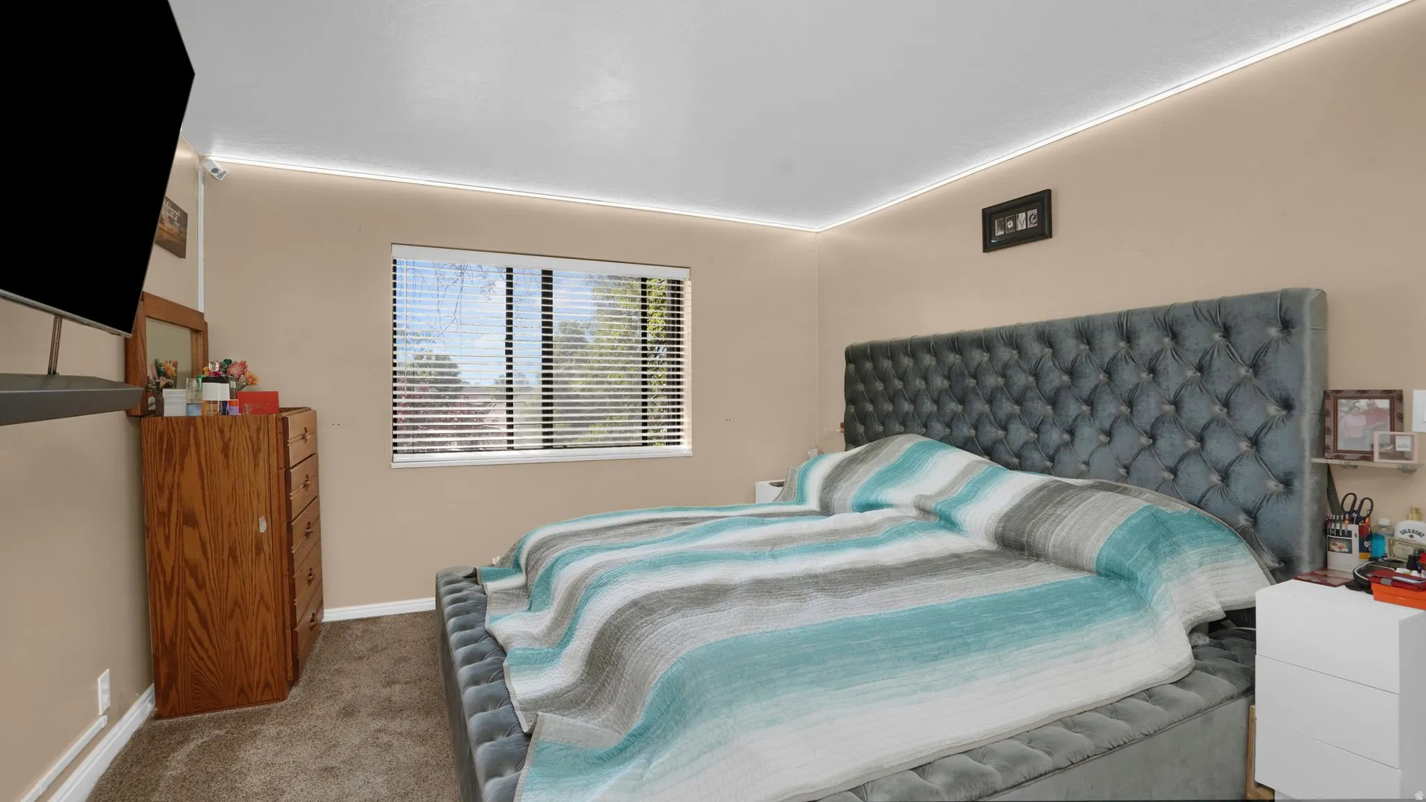 Carpeted bedroom featuring a large window with blinds, beige wall paint, and recessed ceiling lighting