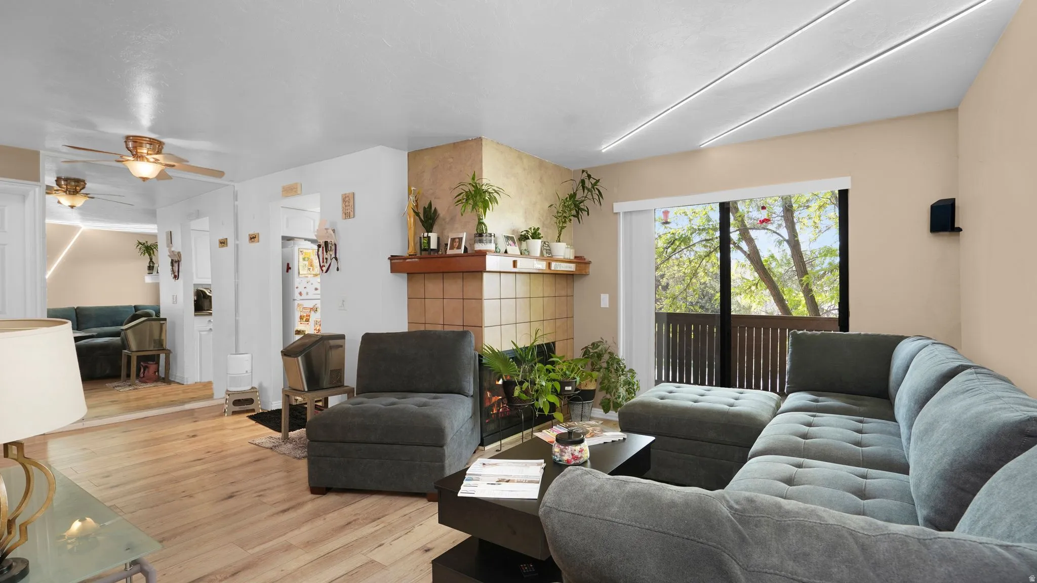 Living area featuring light wood-finish flooring and a fireplace with a tiled surround