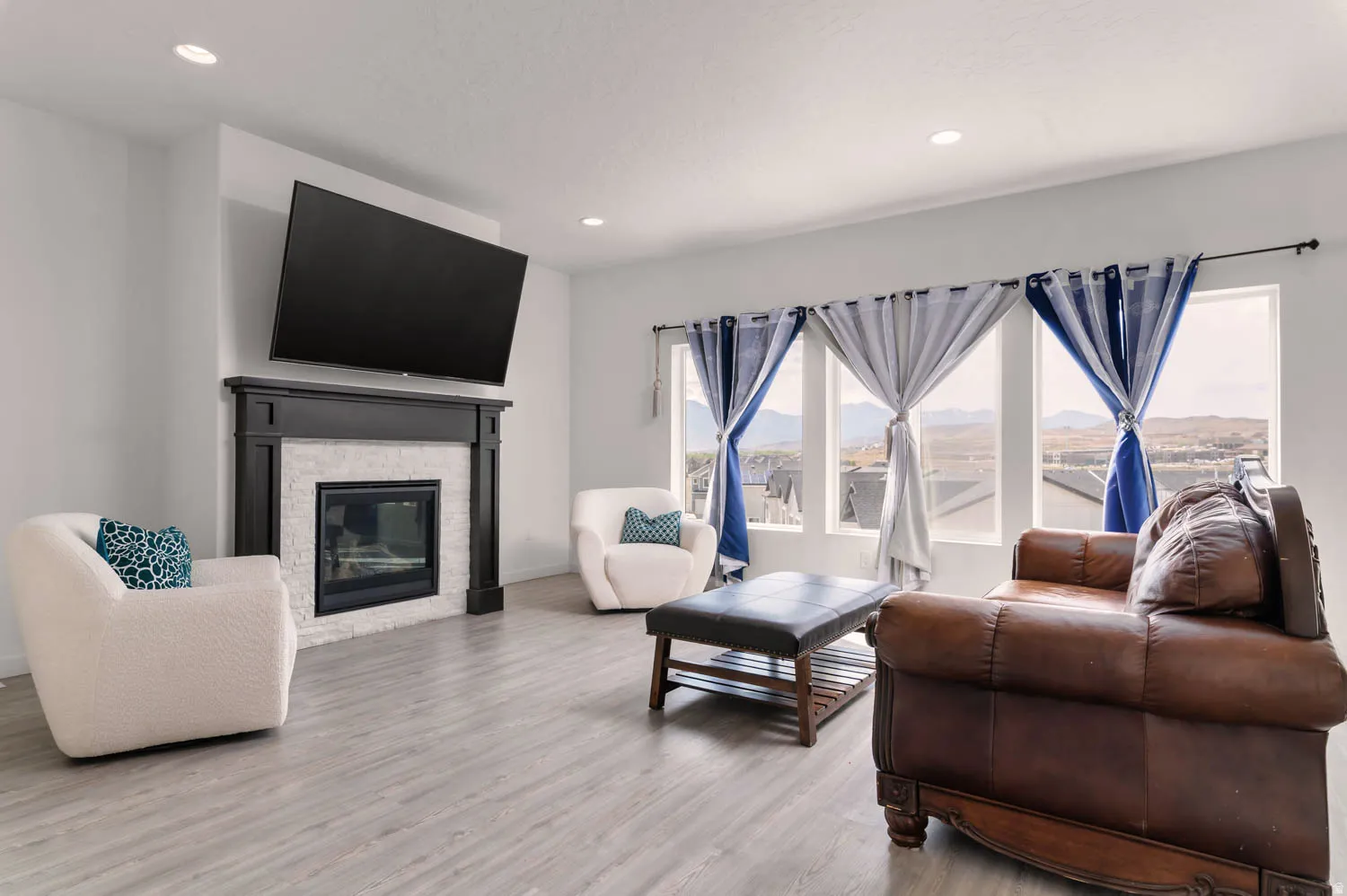 Living area featuring a fireplace with a black mantel and white tile surround