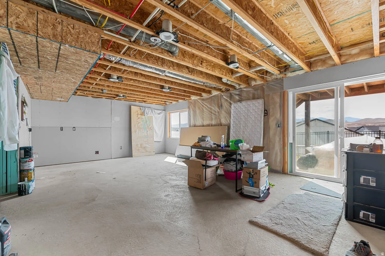 Unfinished walkout lower level offering customization potential, featuring roughed in plumbing for kitchen, washer and dryer