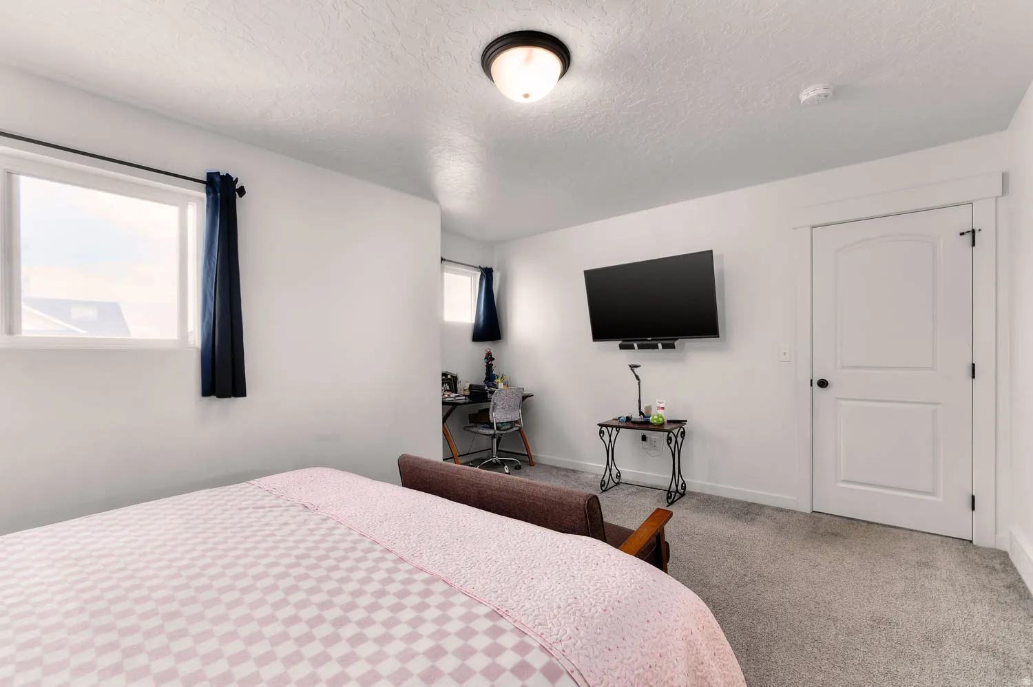 Carpeted room featuring white walls and a ceiling-mounted light fixture