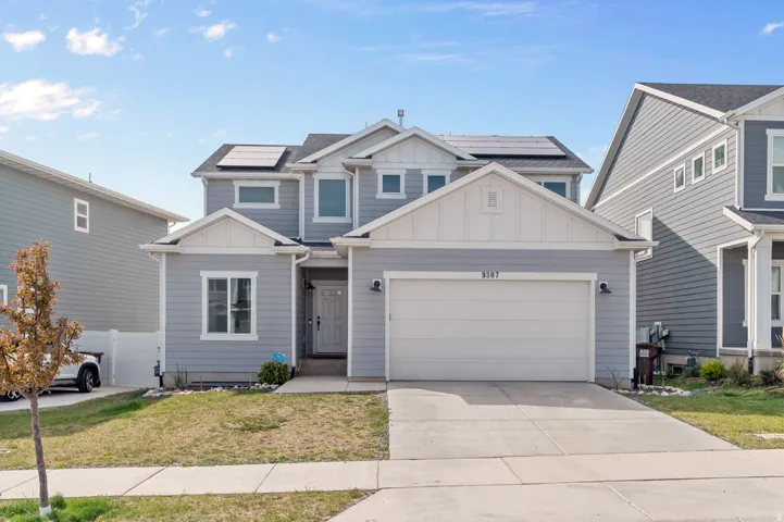 Contemporary two-story residence featuring light gray siding and white trim accents