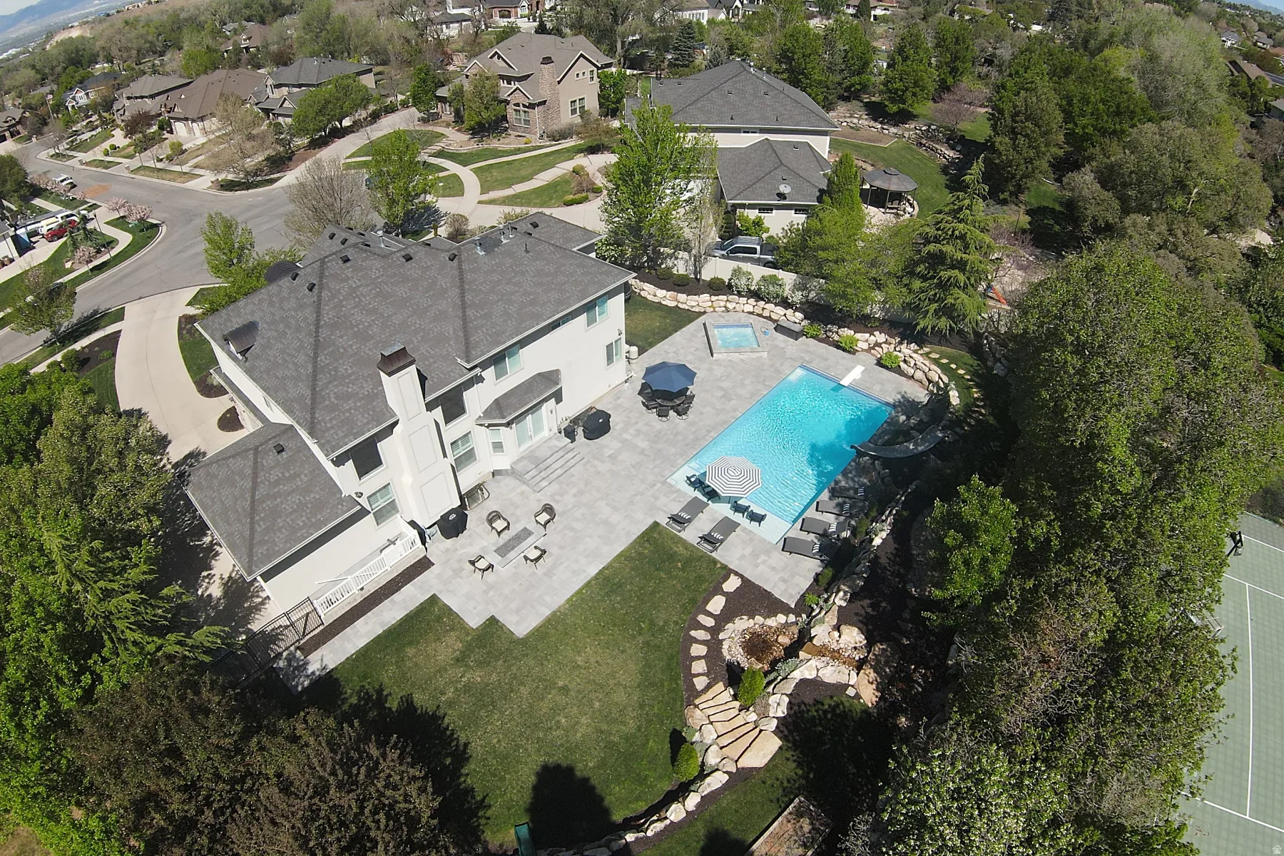 Spacious residence featuring a large patio, built-in swimming pool, integrated spa, and a tennis court