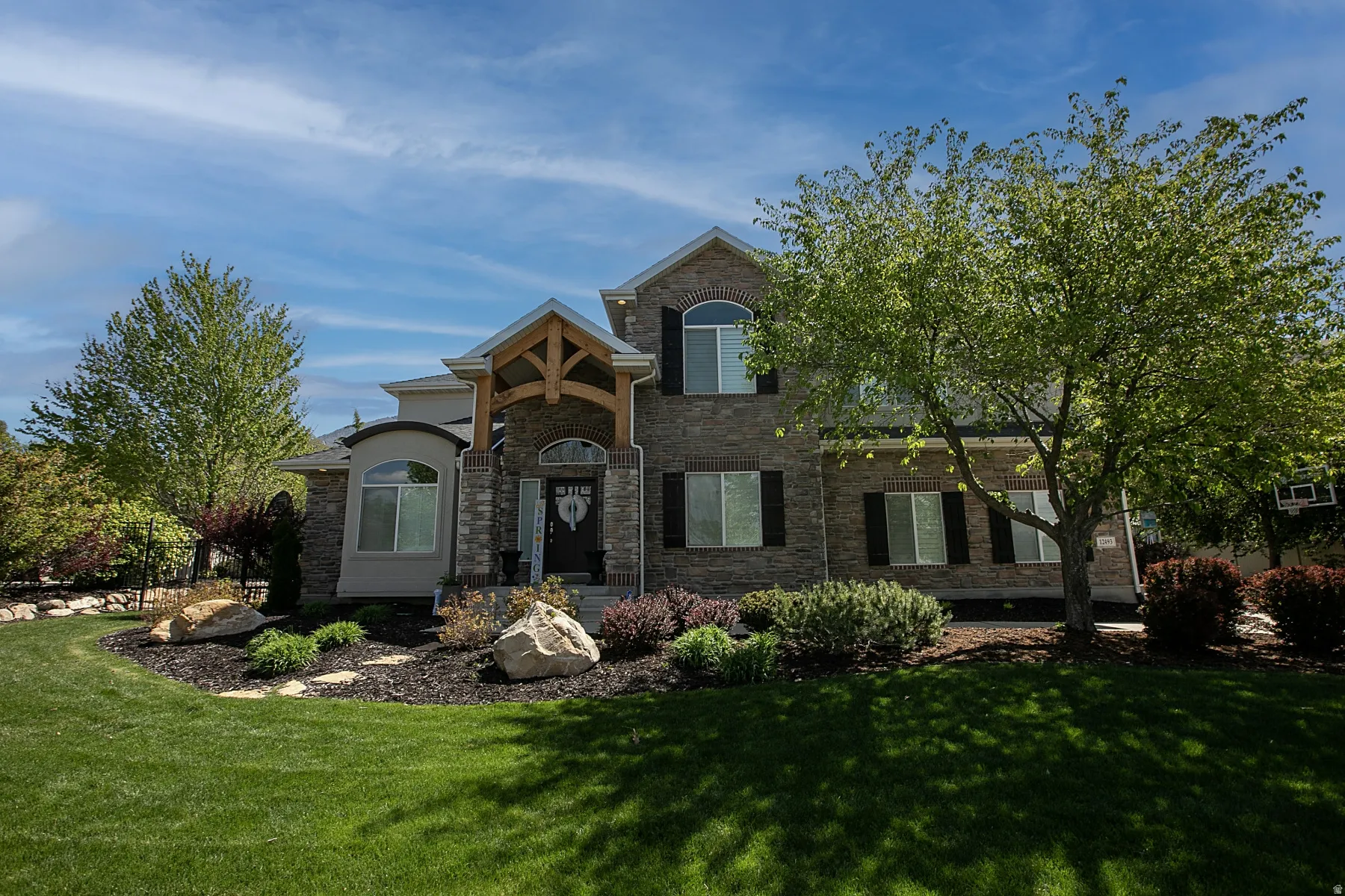 Stone facade residence featuring a prominent timber-framed portico entrance