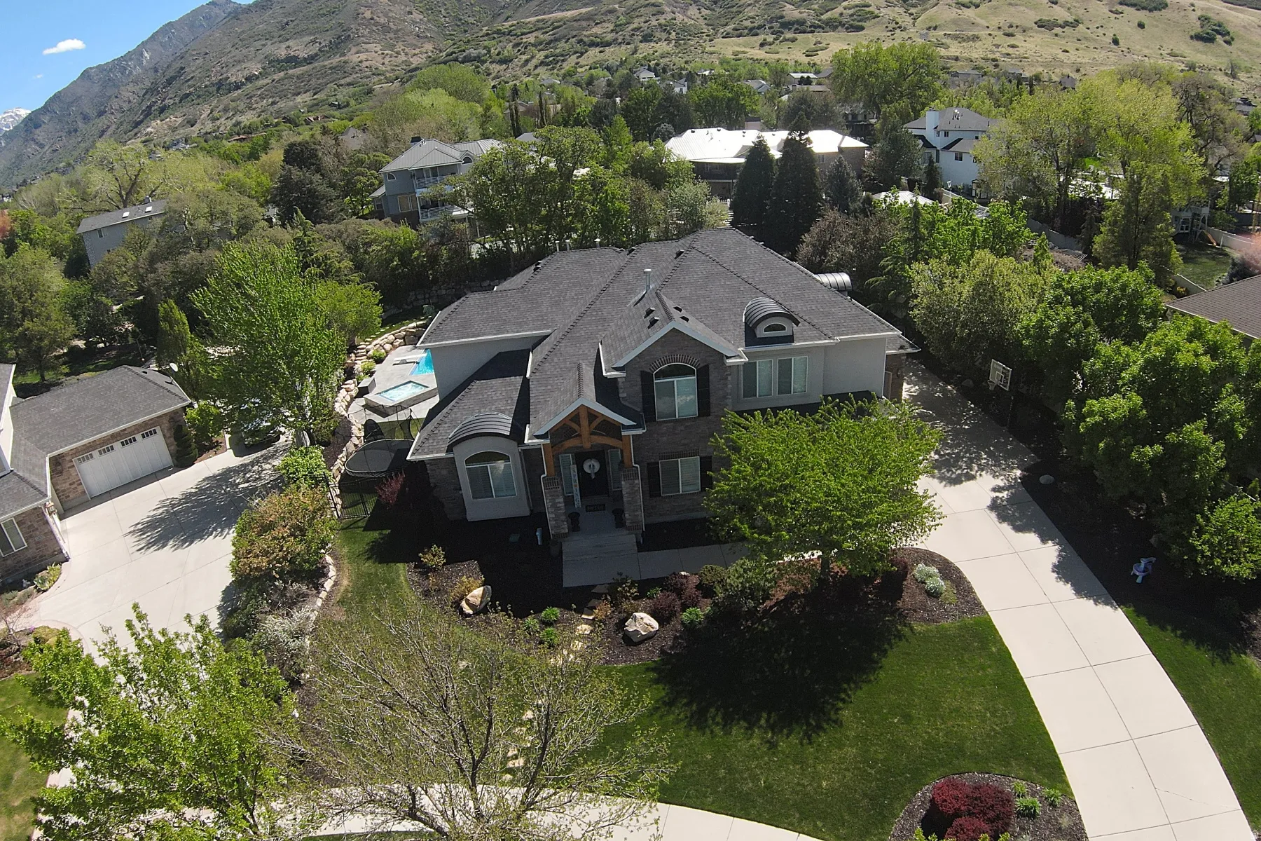 Stone and siding exterior residence with a charcoal shingle roof