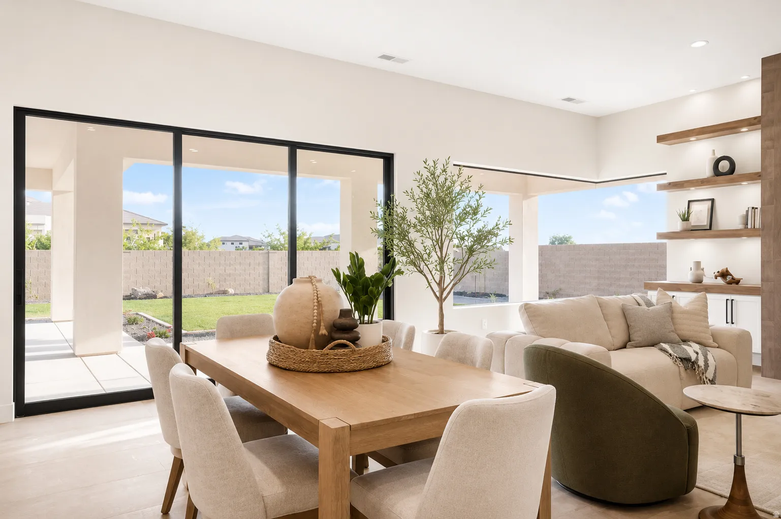 Open-concept interior featuring wood-finish flooring and expansive black-framed sliding glass doors leading to a backyard patio