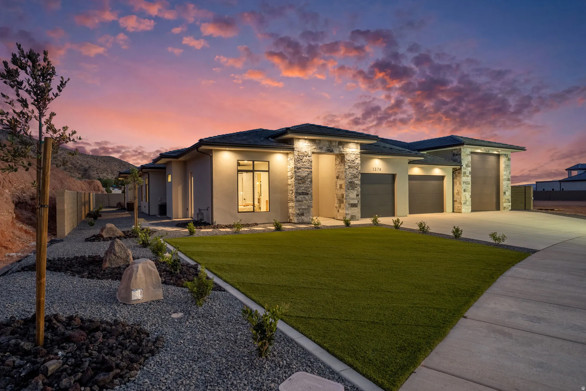 Modern stucco exterior with stone accents and a multi-car garage