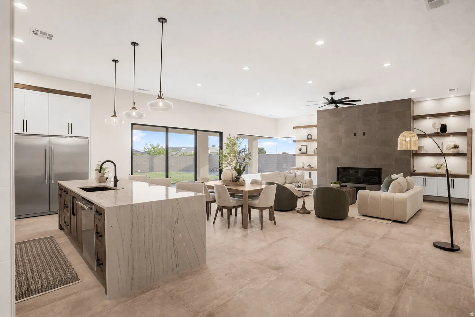 Open-concept great room with large format tile flooring and abundant natural light