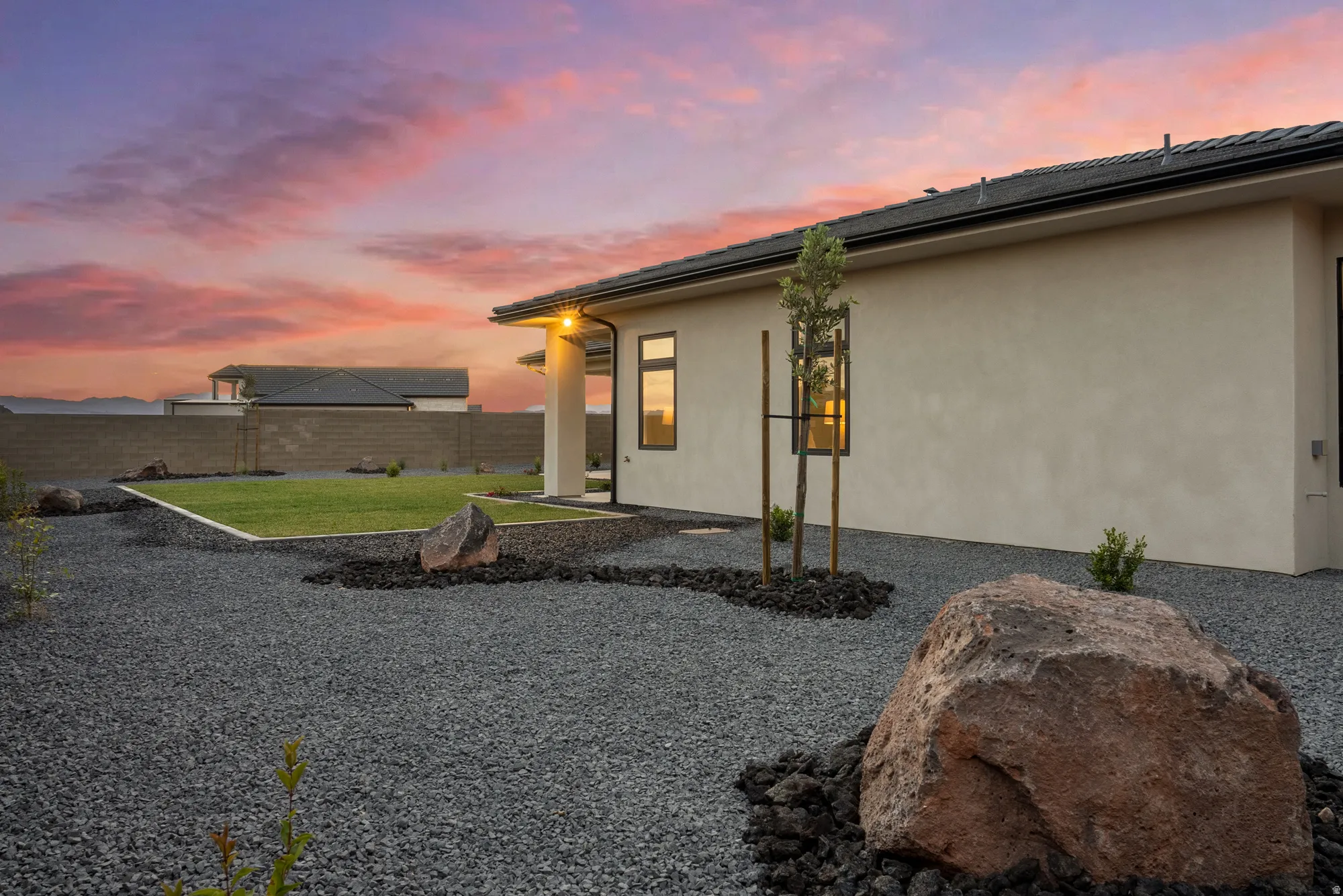 Stucco exterior featuring a tiled roofline and dark-framed windows