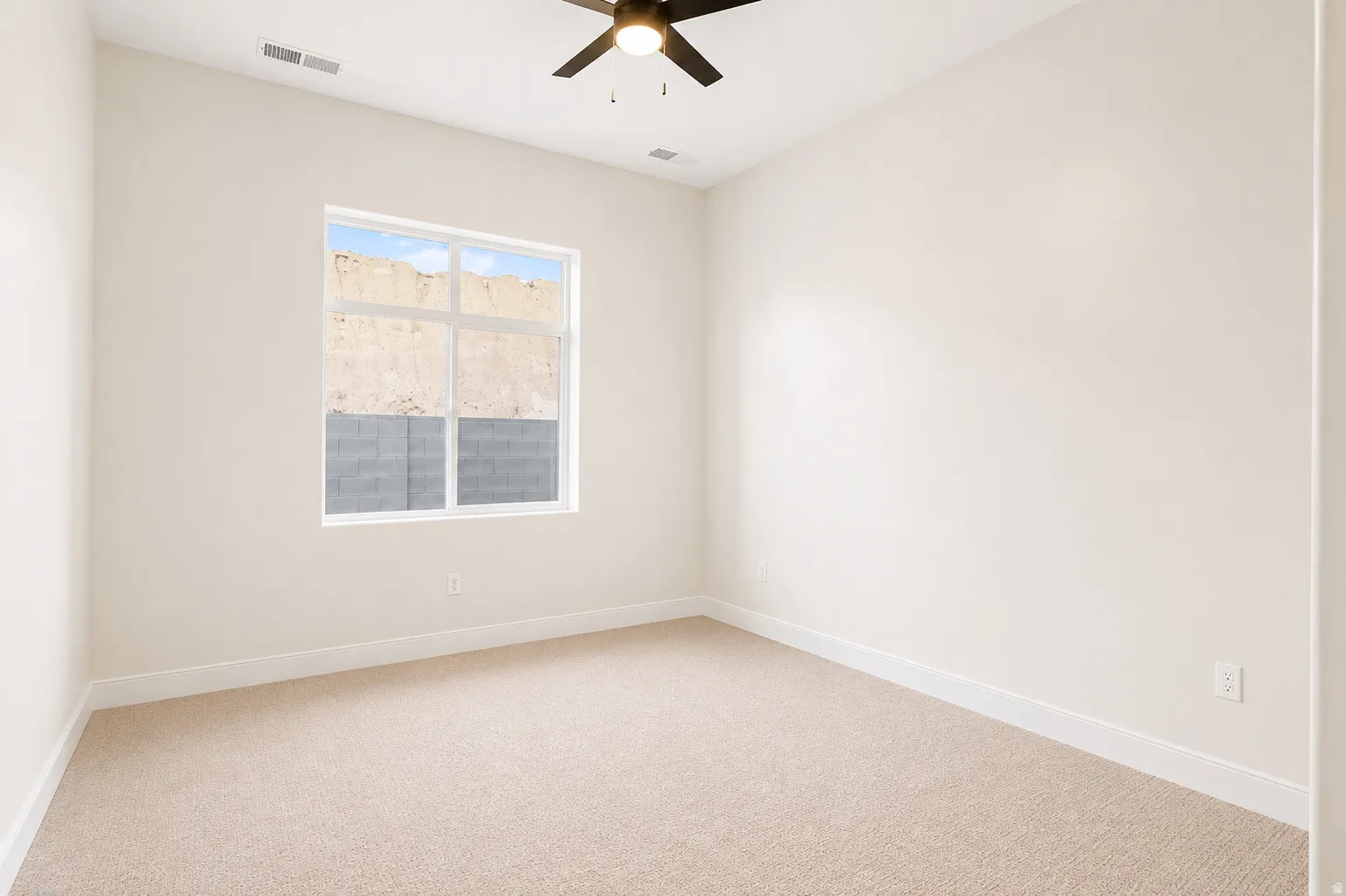 Carpeted room featuring a ceiling fan, a window with a white frame, and baseboard molding