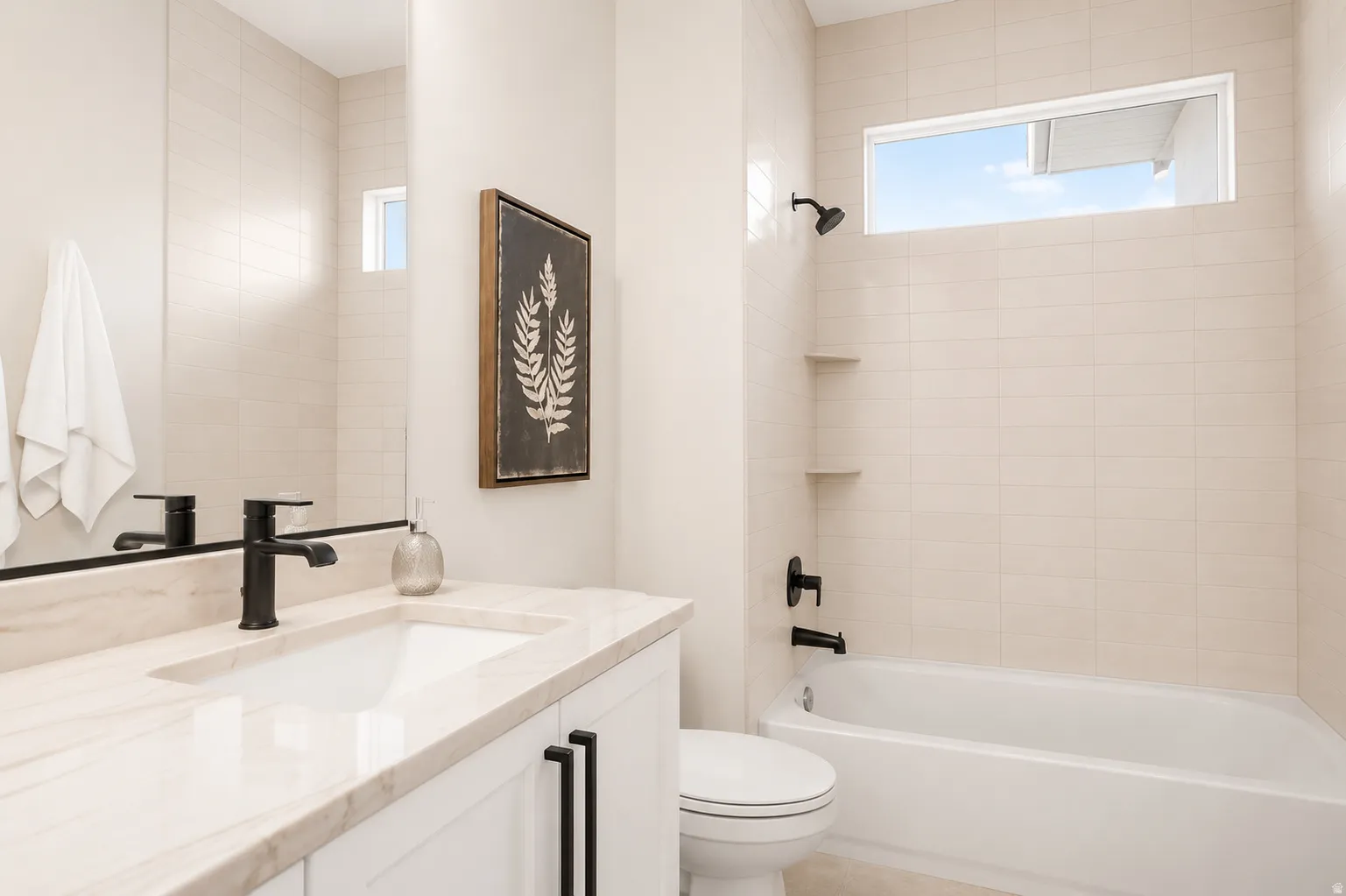 Bathroom featuring a white vanity with a light-toned countertop, an integrated sink, and matte black fixtures