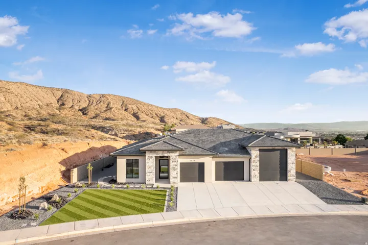 Modern stucco and stone-clad exterior with a three-car garage
