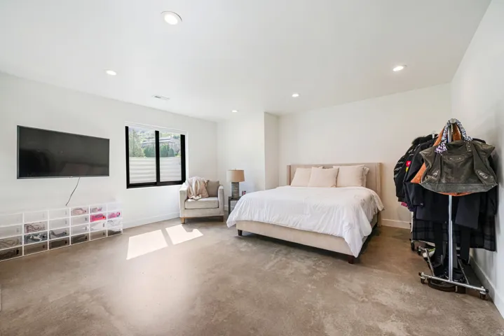 Spacious room featuring neutral walls, recessed lighting, a modern window with black trim, and light-toned carpet flooring