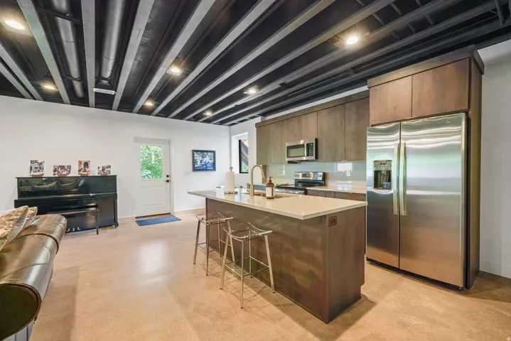 Modern kitchen featuring stainless steel appliances, a center island with countertop seating, and wood-finish cabinetry