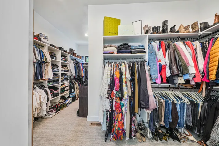 Custom closet system featuring extensive shelving, multiple hanging rods, and integrated storage solutions